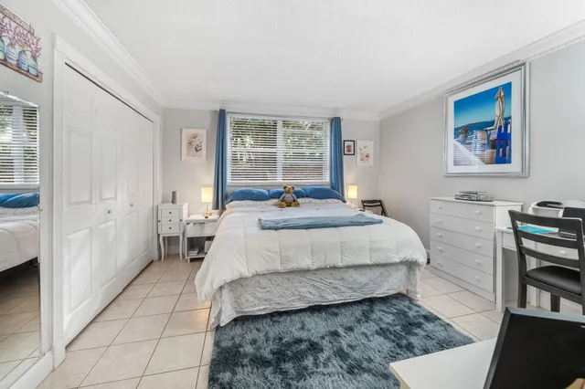 a bedroom with a bed a dresser and next to a window