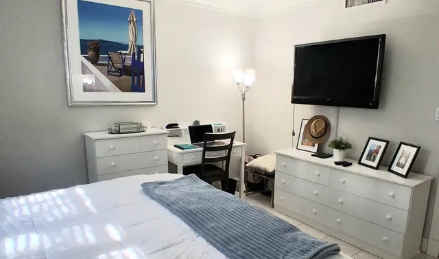 a bedroom with a bed and a flat screen tv