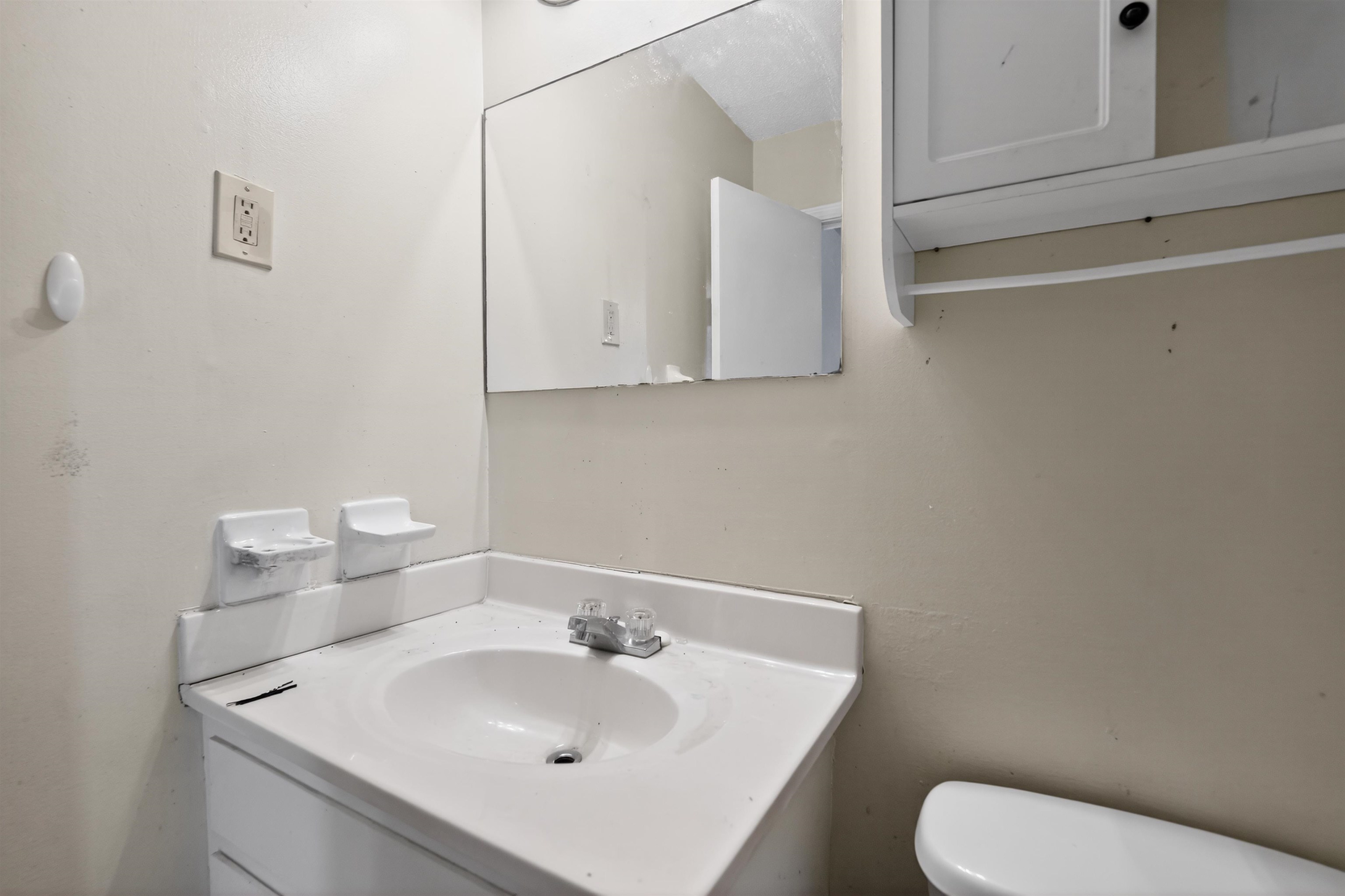 3372 Spring Shadow Drive Memphis, TN 38118 - Photo 29 of 35 Bathroom vanity with an integrated sink and chrome faucet, featuring a wall-mounted mirror and an overhead medicine cabinet