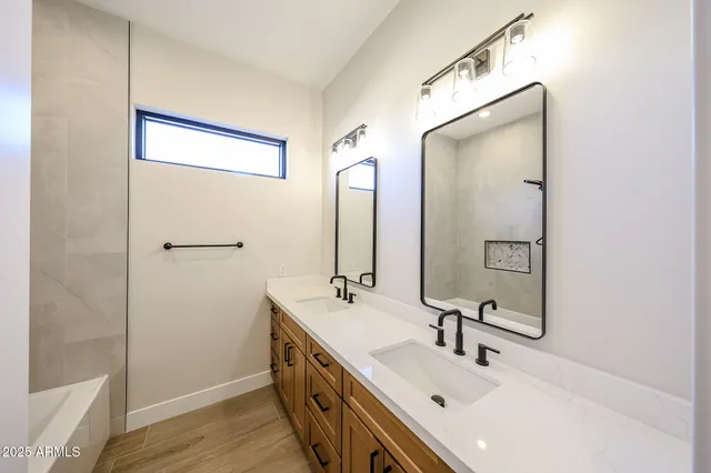 a bathroom with a double vanity sink a mirror and a shower