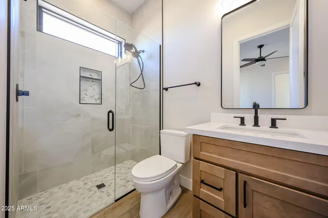 a bathroom with a sink toilet a mirror and shower