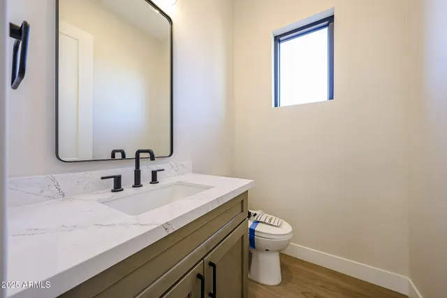 a bathroom with a granite countertop sink a toilet and a mirror