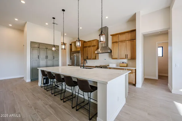 a kitchen island with stainless steel appliances kitchen island granite countertop a table chairs in it and wooden floors
