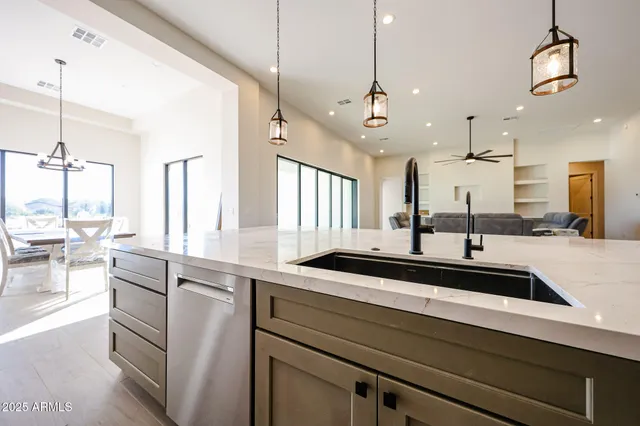 a view of a kitchen counter top a sink and dishwasher with wooden floor