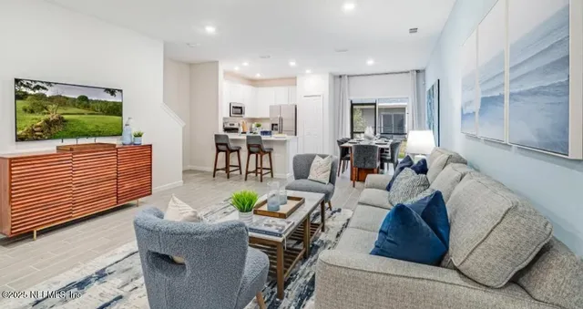 a kitchen with stainless steel appliances granite countertop a table chairs and a refrigerator