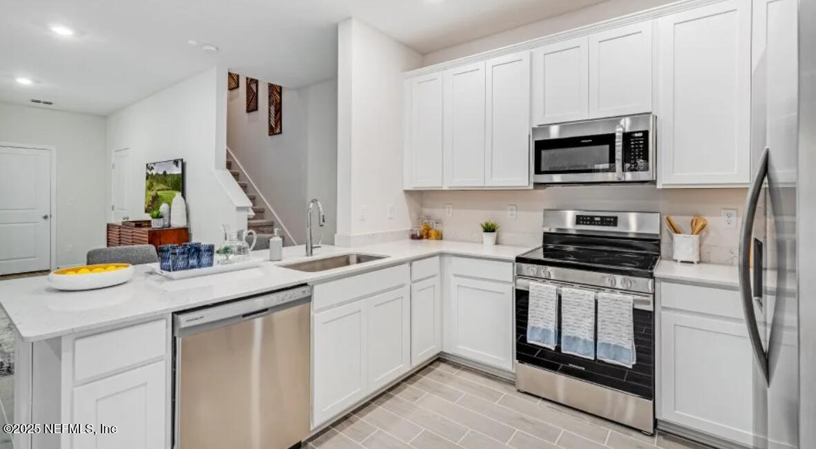 150 Hubbard Bend St. Augustine, FL 32092 - Photo 29 of 37 a kitchen with stainless steel appliances granite countertop a sink stove and microwave