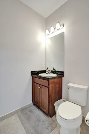 a bathroom with a toilet a sink and mirror