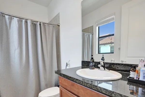 a bathroom with a granite countertop sink and a mirror