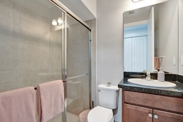 a bathroom with a granite countertop sink toilet and shower