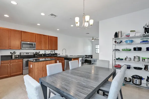 a large kitchen with granite countertop lots of counter space and stainless steel appliances