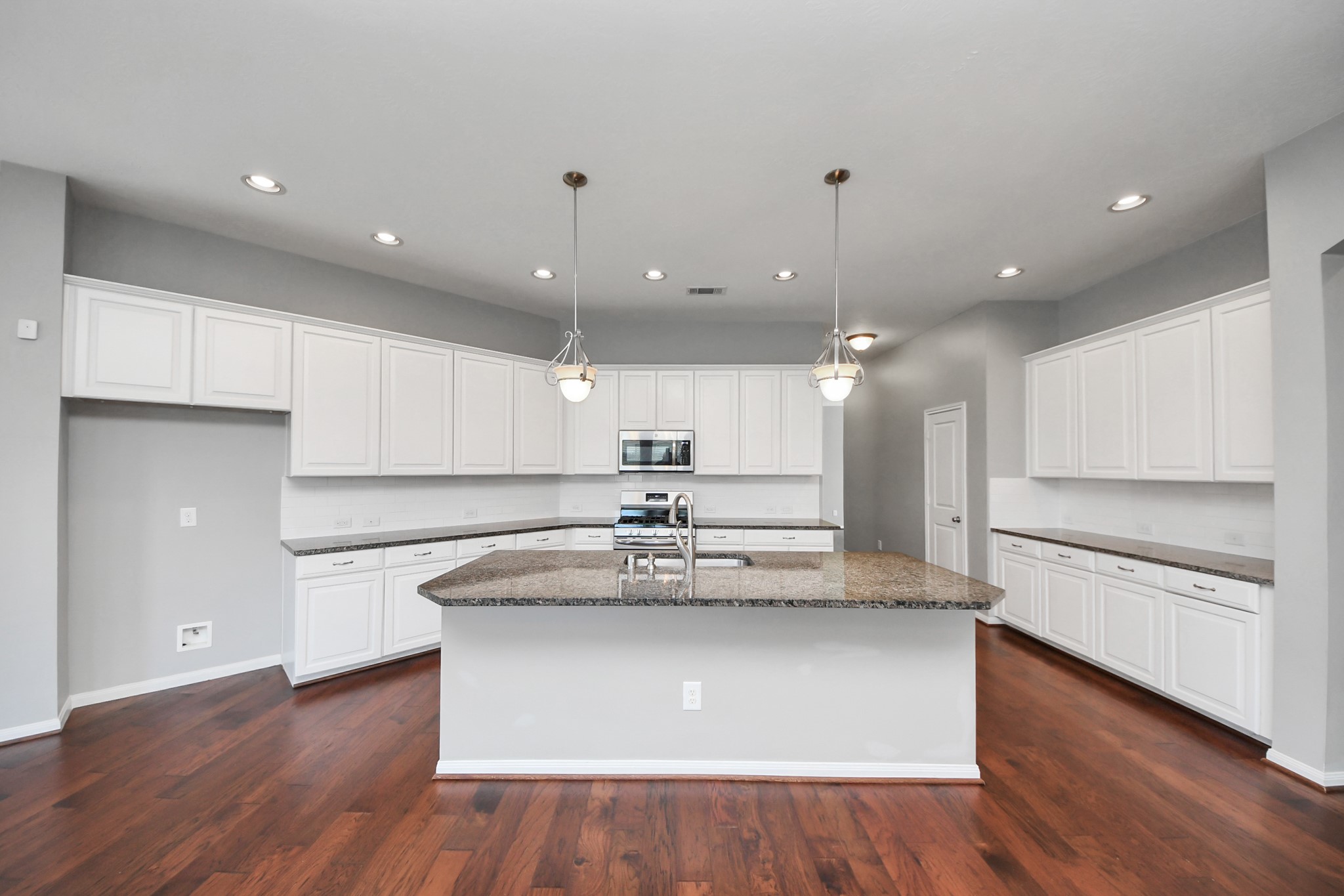 12427 Point Arbor Court Tomball, TX 77377 - Photo 9 of 50 a view of kitchen with granite countertop stainless steel appliances counter space and wooden floor