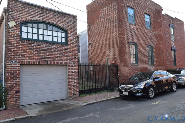 a view of a brick house with wooden fence
