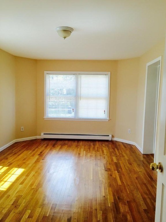 31-35 Juniper Street Boston, MA 02119 - Photo 11 of 14 a view of an empty room with wooden floor and a window