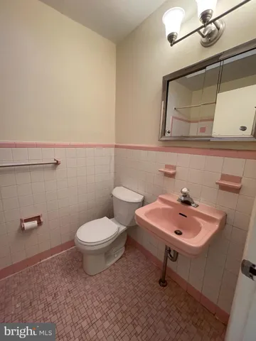 a bathroom with a sink a toilet and mirror