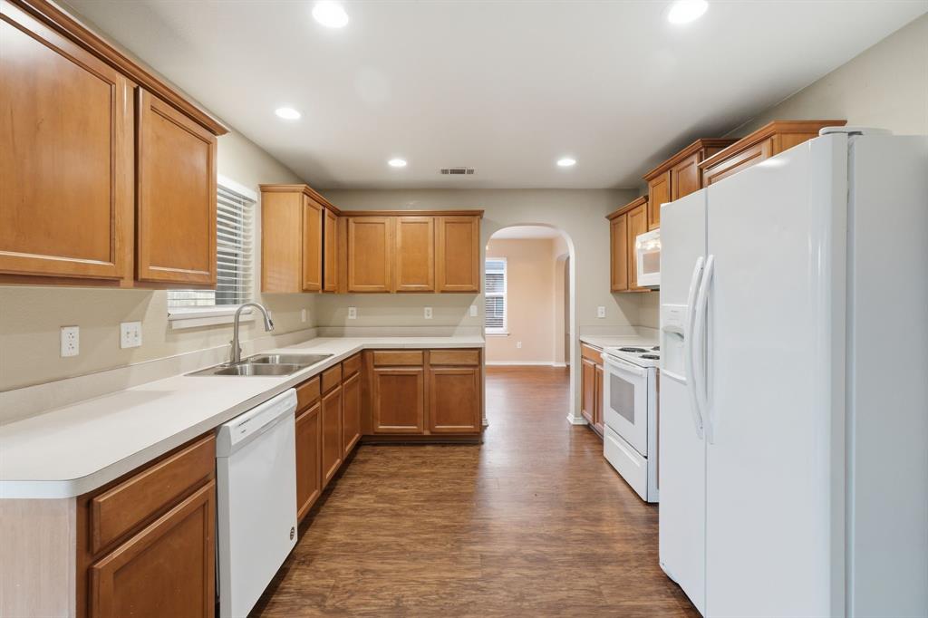 111 Maned Drive Sanger, TX 76266 - Photo 14 of 40 a kitchen with stainless steel appliances granite countertop refrigerator sink and cabinets