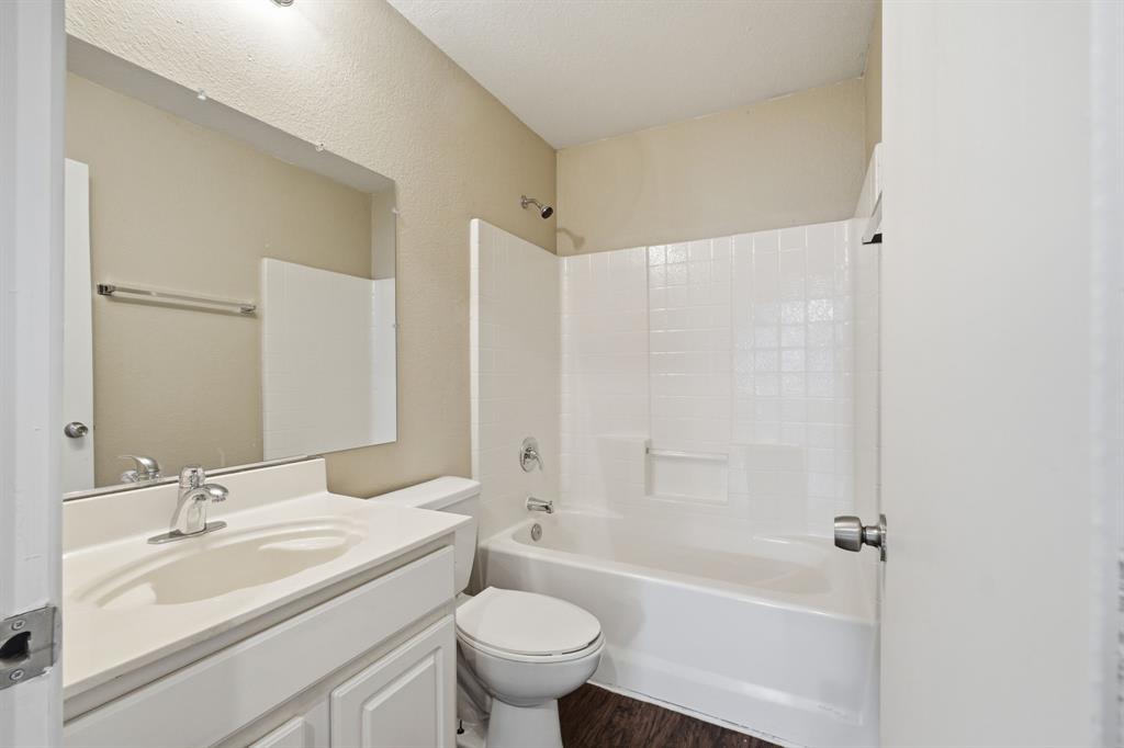 111 Maned Drive Sanger, TX 76266 - Photo 33 of 40 a bathroom with a granite countertop sink toilet and shower