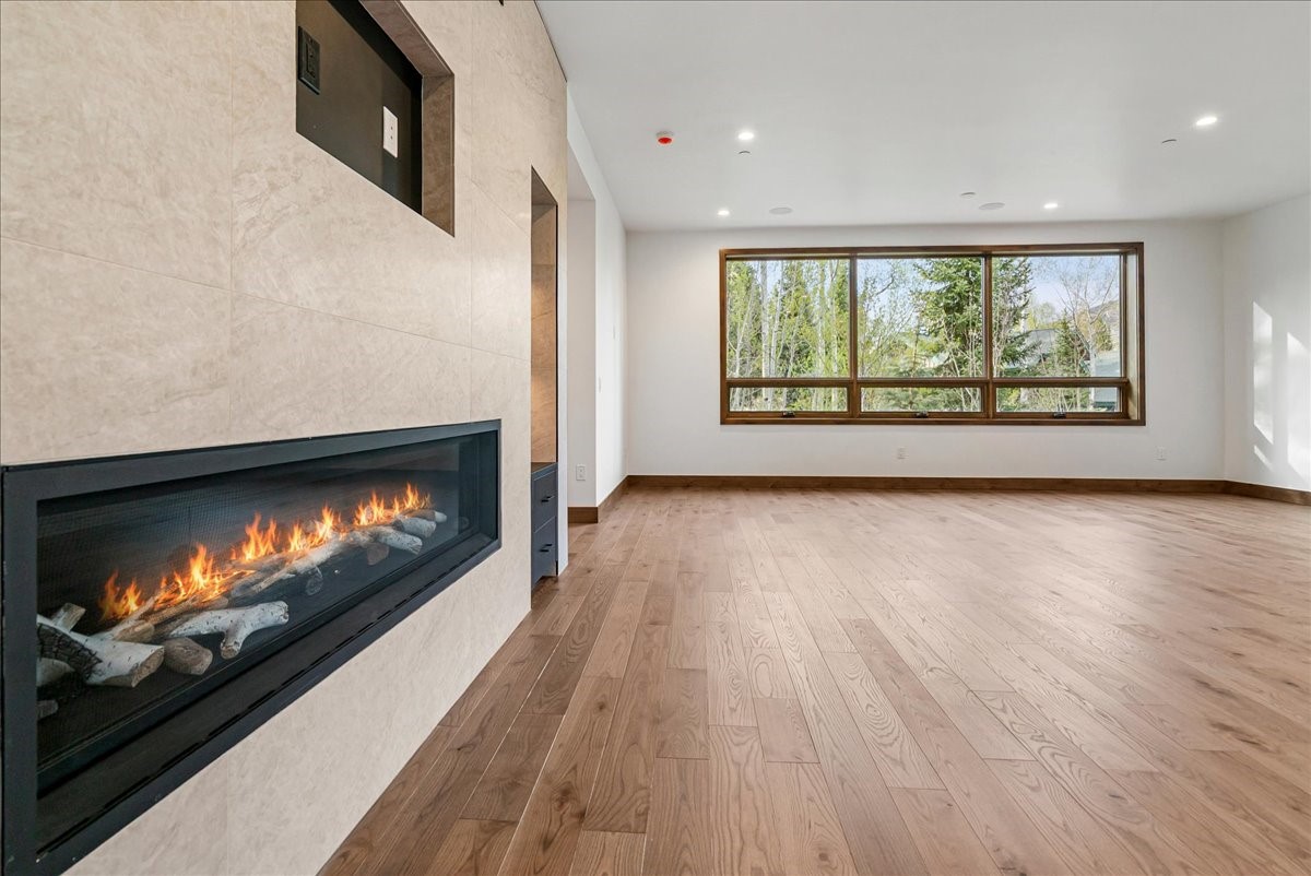 1615 Golden Eagle Road Silverthorne, CO 80498 - Photo 22 of 47 a view of empty room with wooden floor and fireplace
