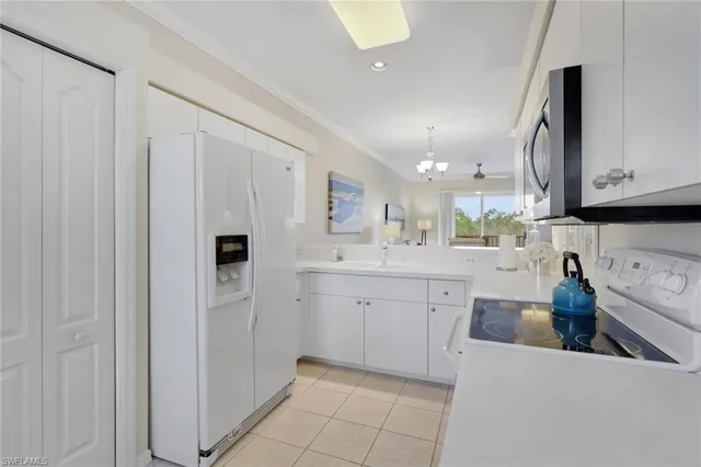 a kitchen with white cabinets and sink