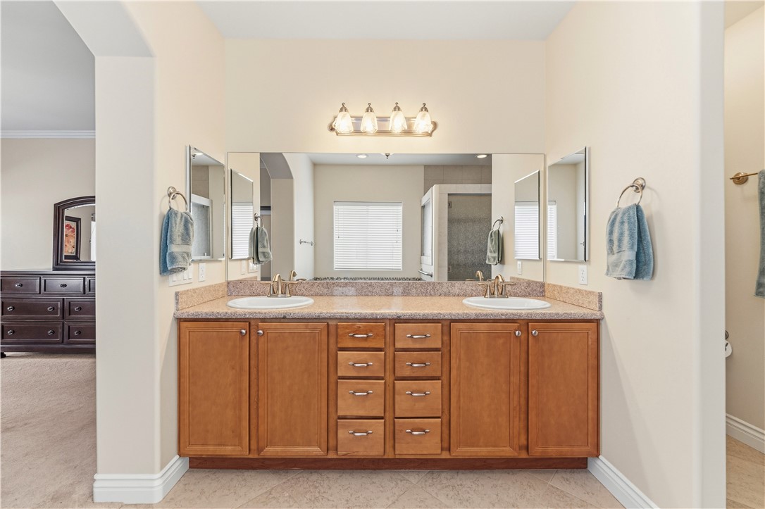 3315 Rainbow Mine Road Kingman, AZ 86401 - Photo 22 of 54 Bathroom featuring a double vanity with light wood cabinetry, a granite-style countertop, dual sinks, and a large mirror with integrated lighting