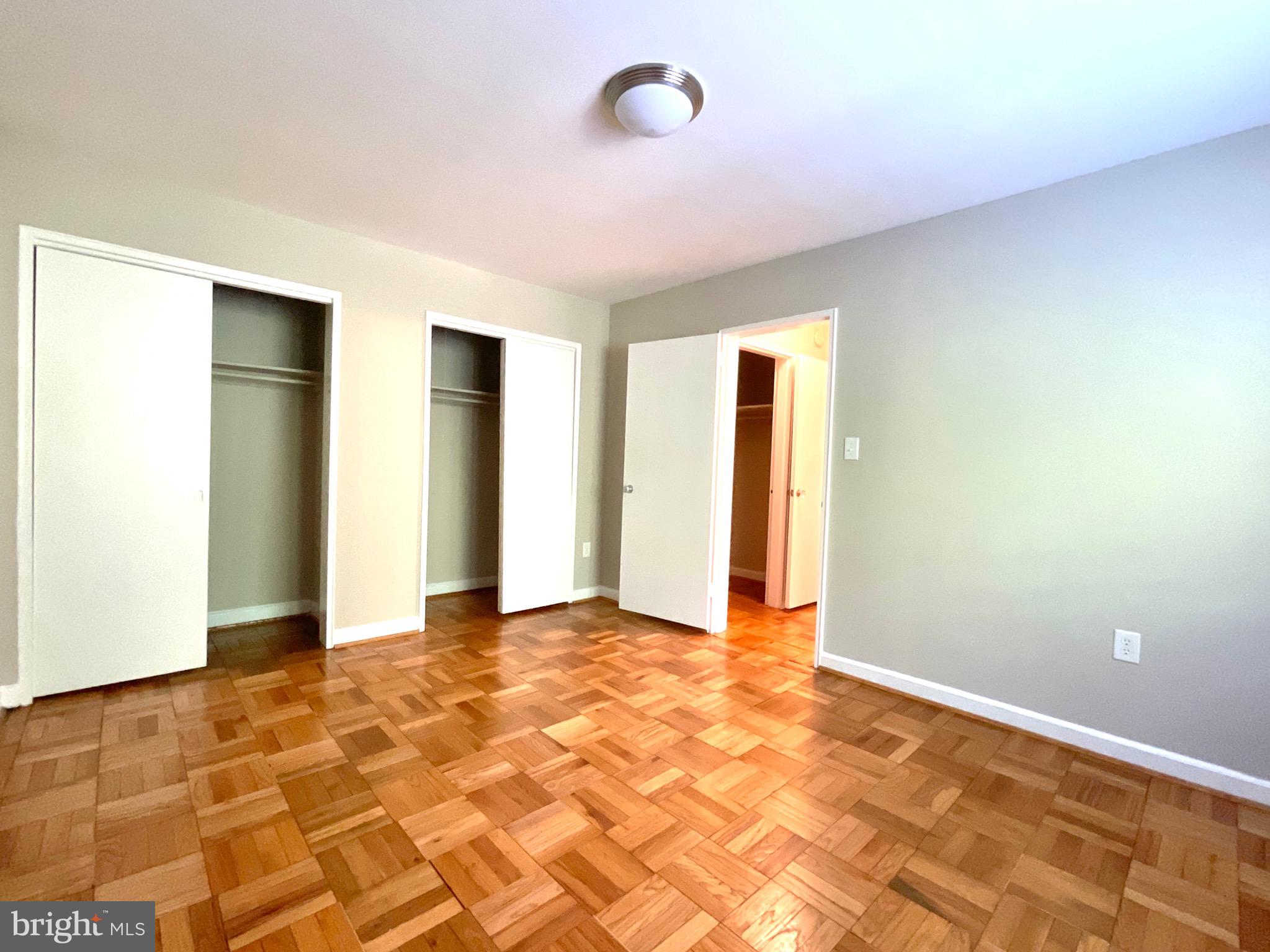 4114 Davis Place Northwest, Unit 210 Washington, DC 20007 - Photo 13 of 19 a view of an empty room with window and wooden floor