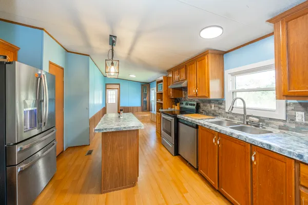 a kitchen with stainless steel appliances granite countertop a sink stove and refrigerator