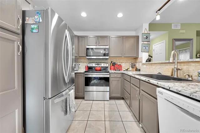 a kitchen with stainless steel appliances granite countertop a refrigerator sink and stove