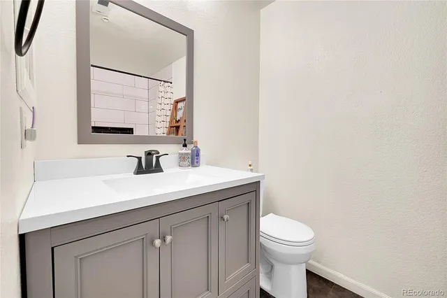 a bathroom with a toilet a sink and mirror
