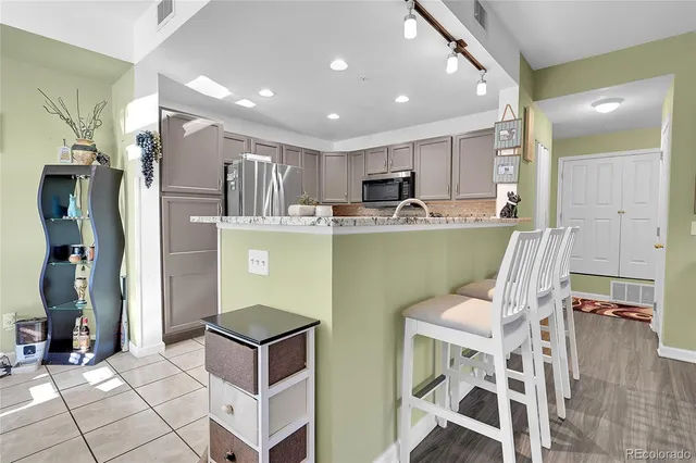 a kitchen with kitchen island a counter top space appliances and cabinets