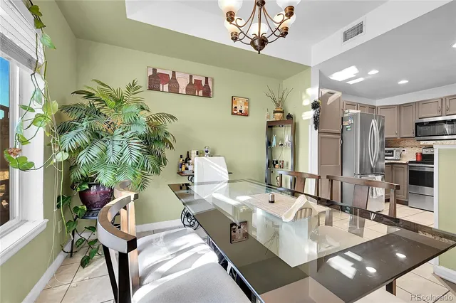 a living room with furniture flowerpot and a chandelier