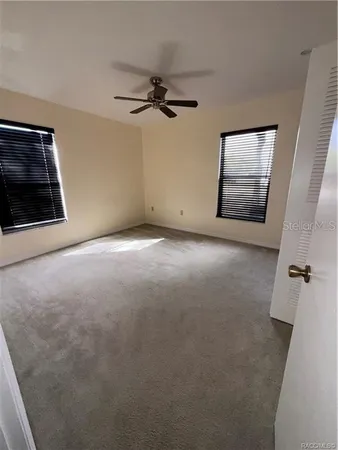 en empty room with windows and fireplace
