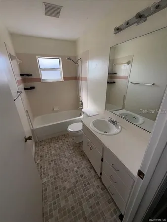 a bathroom with a sink a toilet a mirror and shower