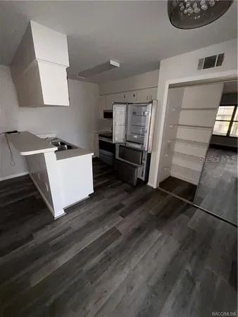 a kitchen with a refrigerator and a stove top oven