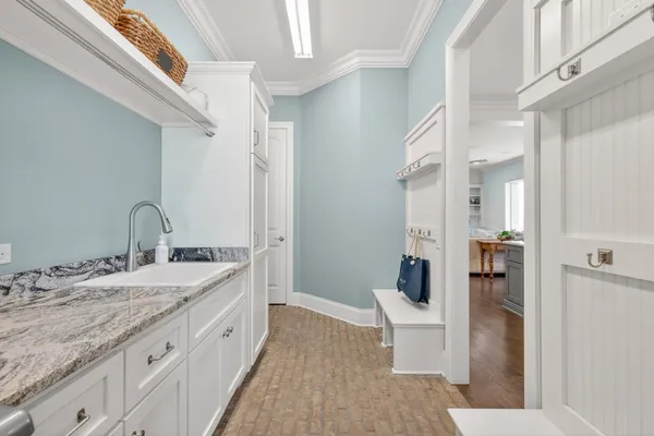 a bedroom with a bed a desk and chair with chandelier