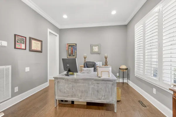 a view of house with a big yard and large trees