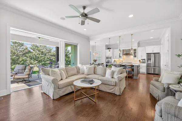 a large kitchen with kitchen island a dining table chairs and white cabinets
