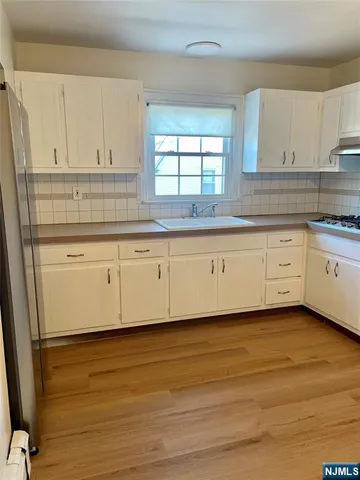 a kitchen with granite countertop white cabinets and white appliances