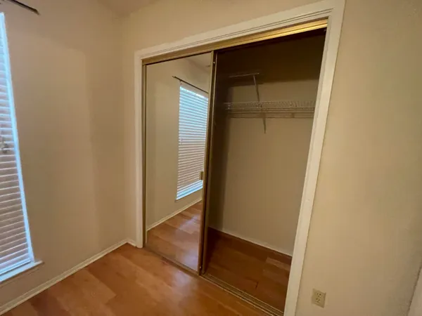 an empty room with wooden floor and closet