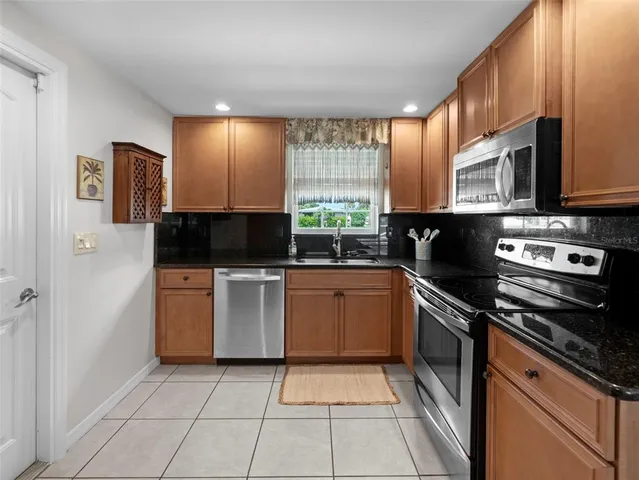 a kitchen with stainless steel appliances granite countertop a stove a sink and a microwave