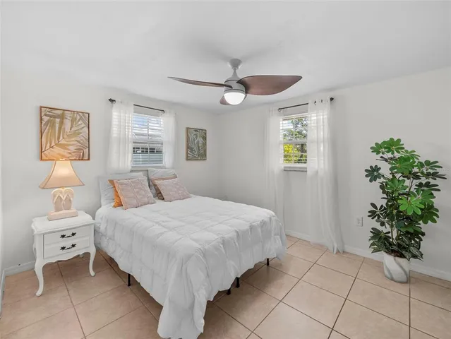 a spacious bedroom with a bed and a potted plant