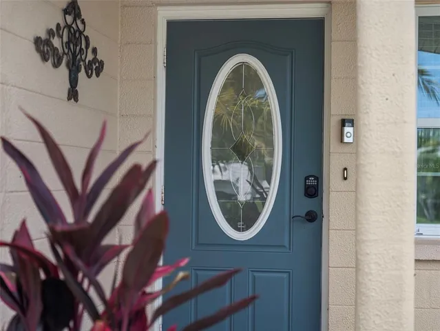 a living room with furniture a chandelier and a floor to ceiling window