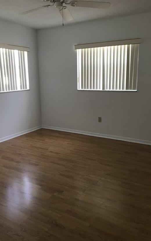 22705 Southwest 65th Terrace Boca Raton, FL 33428 - Photo 5 of 15 an empty room with wooden floor and windows