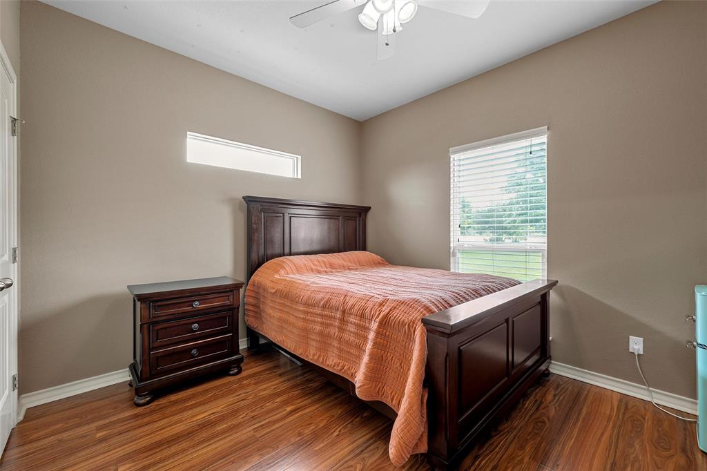 1117 Downsville Road Robinson, TX 76706 - Photo 21 of 40 Spacious room featuring wood-finish flooring, a ceiling fan with integrated lighting, a rectangular window with blinds, and an additional horizontal transom window