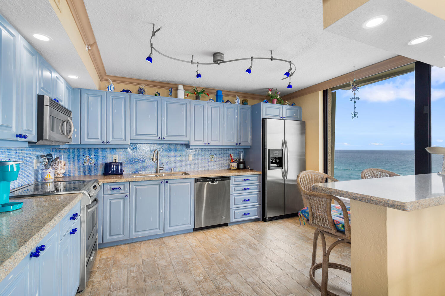 3009 South Ocean Boulevard, Unit 901 Highland Beach, FL 33487 - Photo 23 of 44 a kitchen with kitchen island granite countertop a sink cabinets and stainless steel appliances