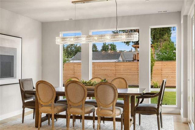 a dining room with furniture a chandelier and wooden floor