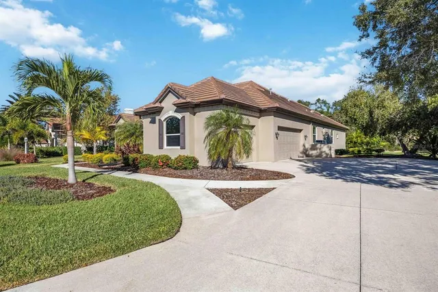 a front view of a house with a yard and potted plants