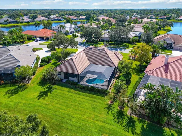 an aerial view of residential houses with outdoor space and trees