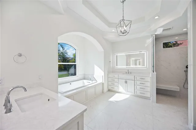 a spacious bathroom with a granite countertop sink a large mirror and shower