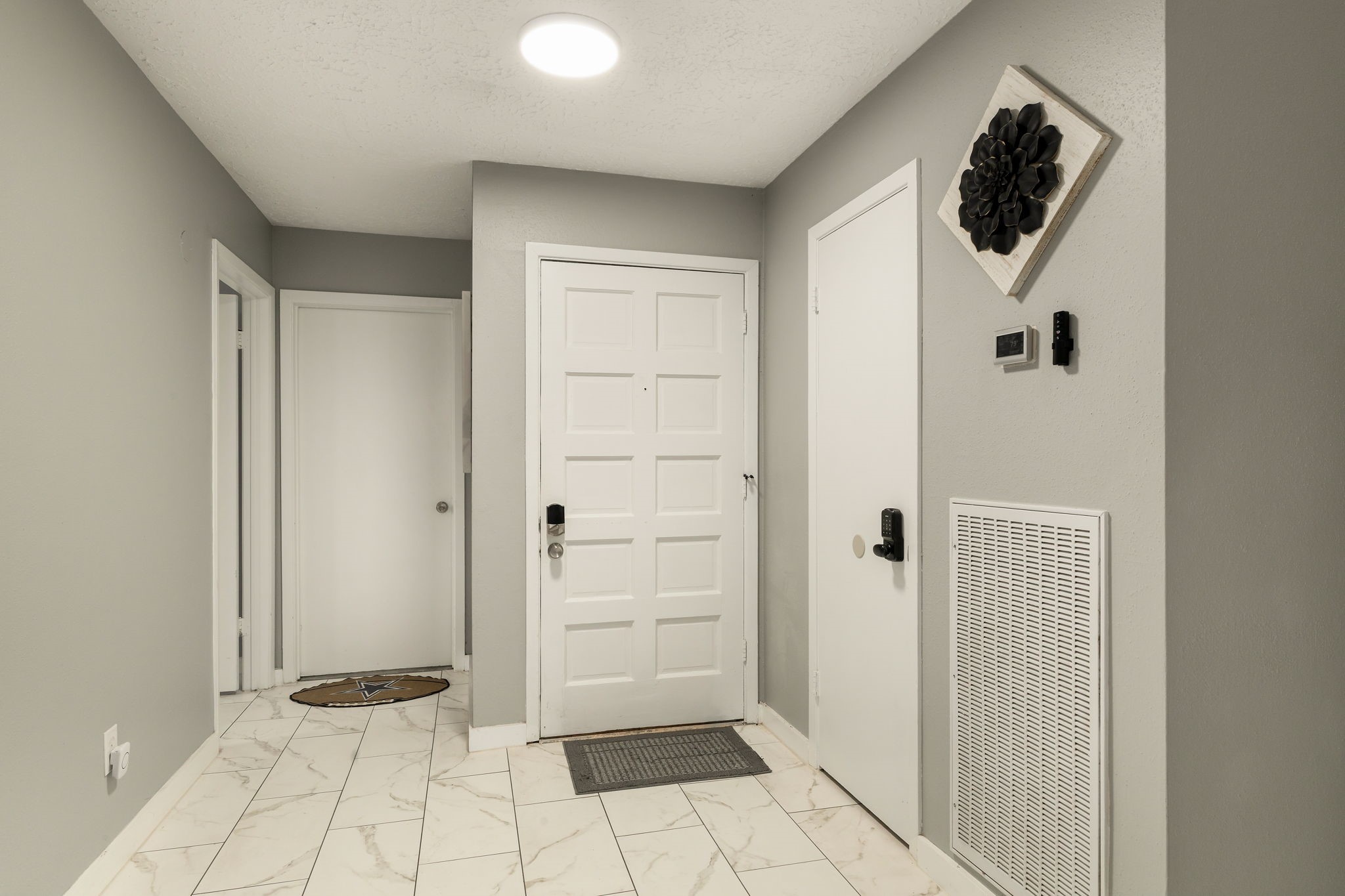 14110 Eventide Drive Cypress, TX 77429 - Photo 11 of 27 This entryway features a modern design with light gray walls, white tile flooring and a closet door as you enter, providing a clean and welcoming entrance.