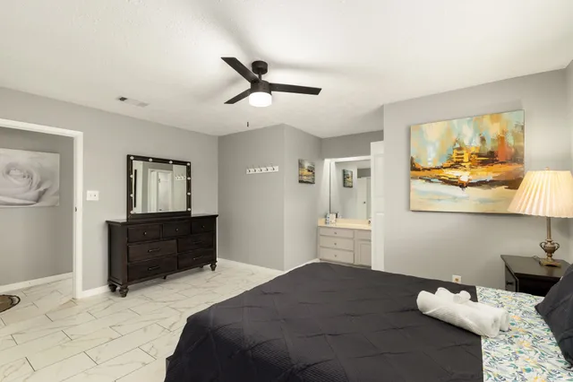 a bathroom with a granite countertop sink toilet a mirror a vanity and shower