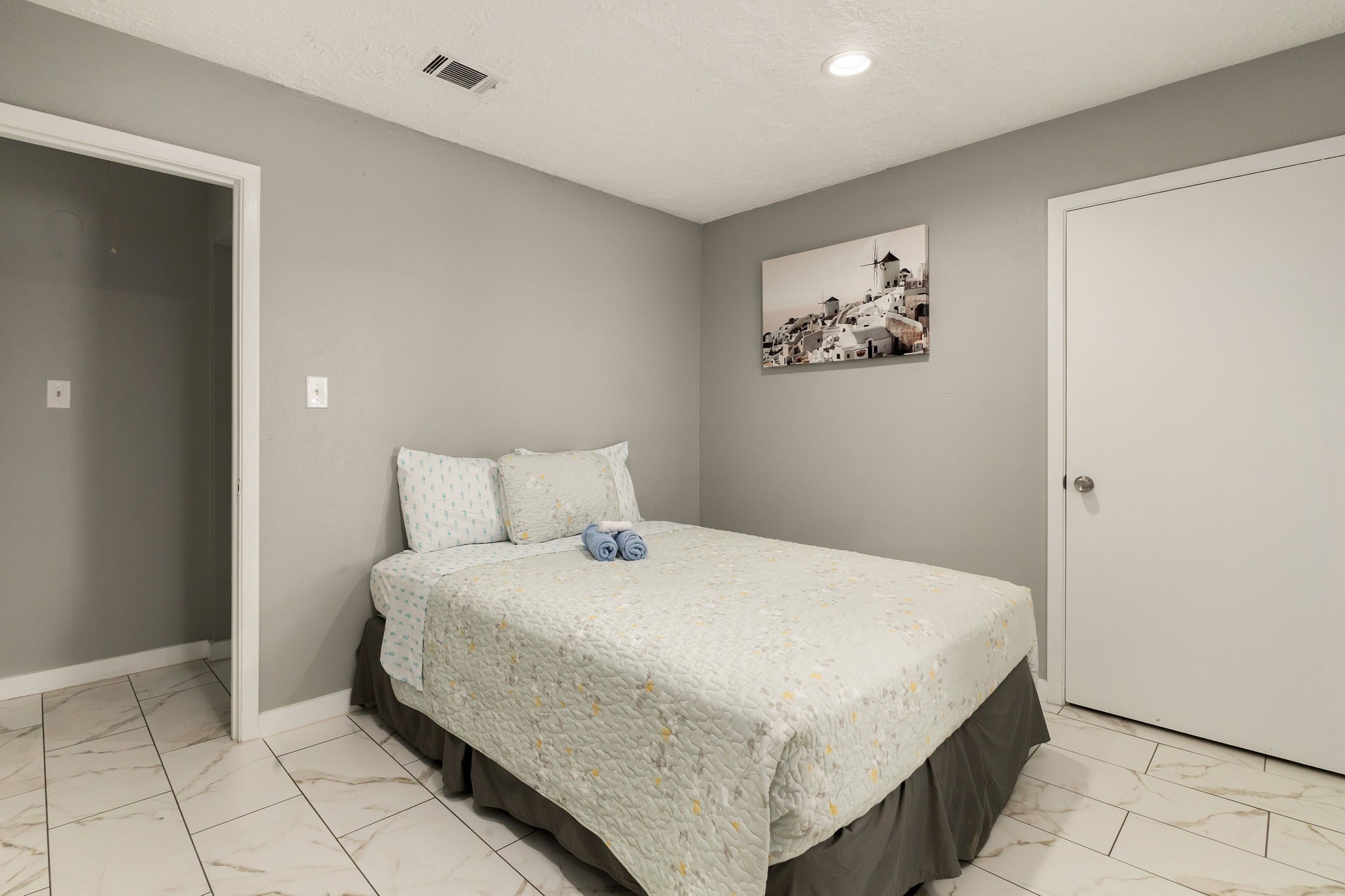 14110 Eventide Drive Cypress, TX 77429 - Photo 18 of 27 This bedroom features a cozy bed with light bedding, tiled flooring, and neutral gray walls. A simple piece of artwork can add charm, and recessed lighting provides a modern touch.